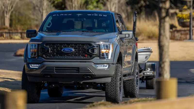 Gray Ford F-150 Black Widow lifted truck towing a bass boat