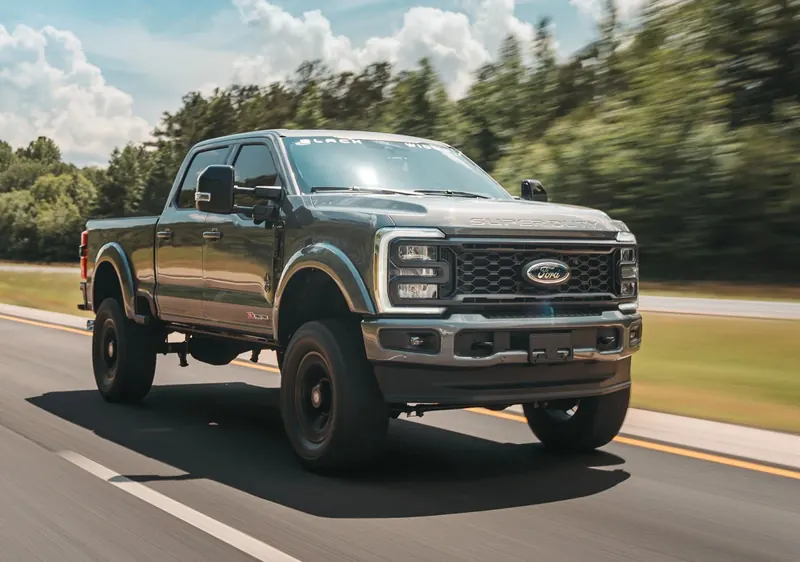 Gray Ford Super Duty Black Widow lifted truck driving on the highway