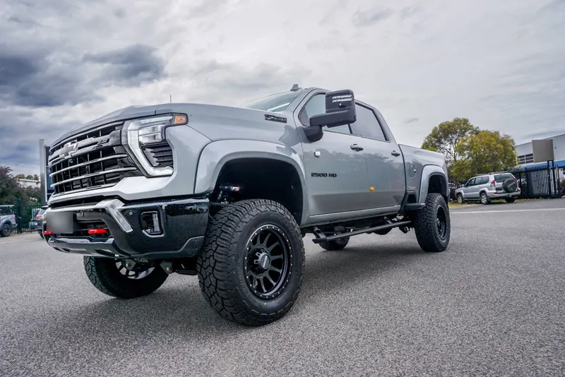 Gray lifted Chevrolet Silverado 2500HD Z71 with black wheels and all-terrain tires
